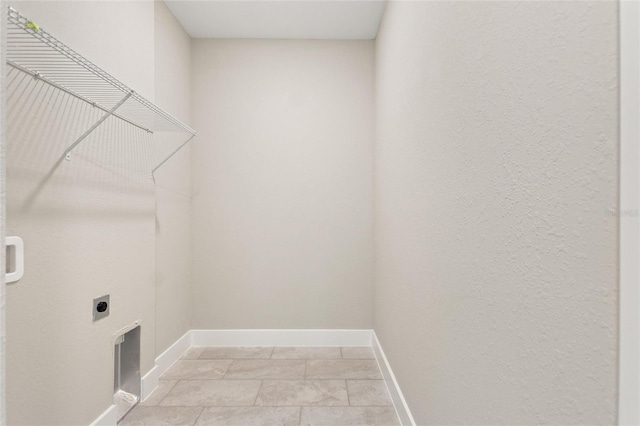 washroom with electric dryer hookup and light tile patterned floors