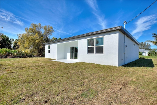 rear view of property featuring a patio and a lawn