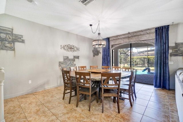 dining room featuring light tile patterned floors, a textured ceiling, and a notable chandelier