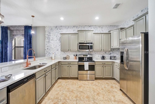 kitchen with gray cabinetry, sink, and stainless steel appliances