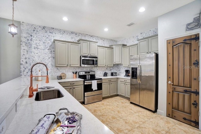 kitchen featuring gray cabinetry, sink, stainless steel appliances, decorative light fixtures, and light tile patterned flooring