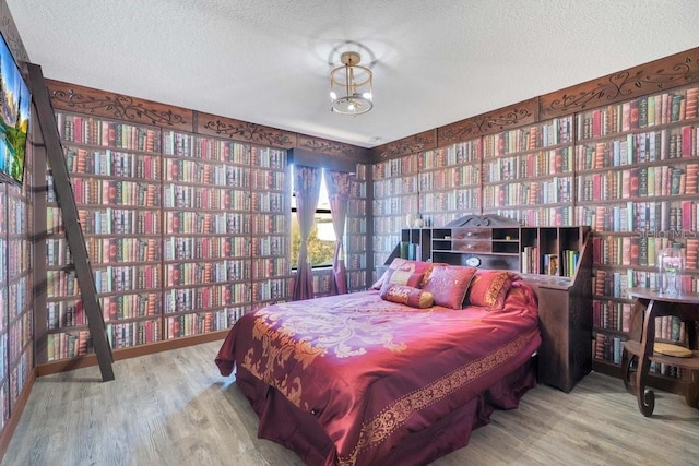 bedroom with hardwood / wood-style floors and a textured ceiling