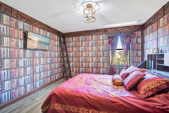 bedroom with a textured ceiling and hardwood / wood-style flooring