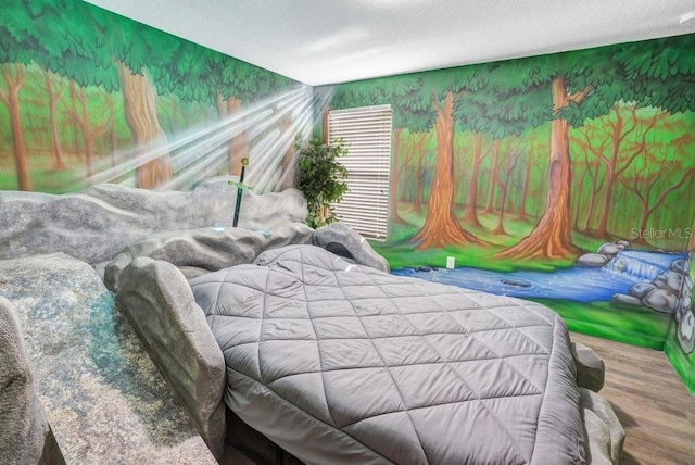 bedroom with hardwood / wood-style floors and a textured ceiling