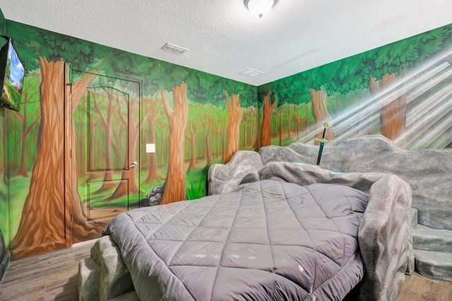 bedroom with hardwood / wood-style floors and a textured ceiling