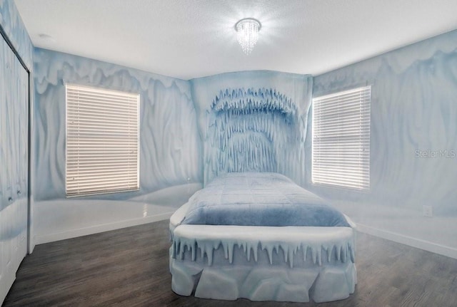 bedroom featuring a closet, dark hardwood / wood-style flooring, and a textured ceiling