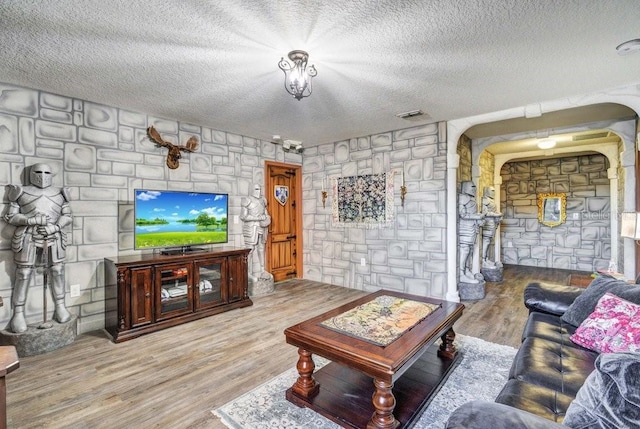 living room featuring wood-type flooring and a textured ceiling