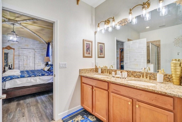 bathroom with wood-type flooring, vanity, and an enclosed shower