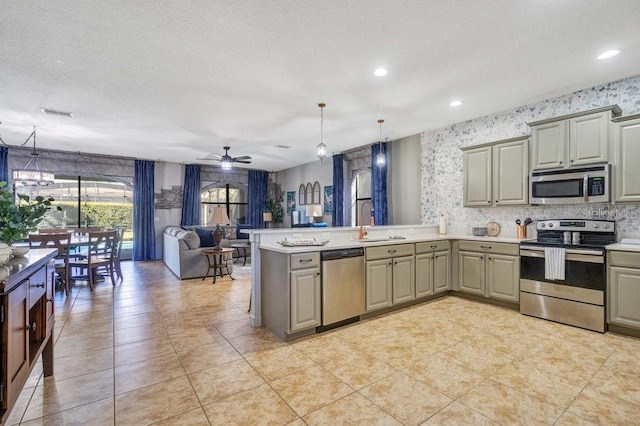 kitchen with sink, pendant lighting, gray cabinets, ceiling fan with notable chandelier, and appliances with stainless steel finishes