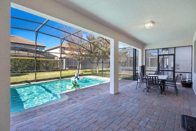 view of pool with glass enclosure, a patio area, and a yard