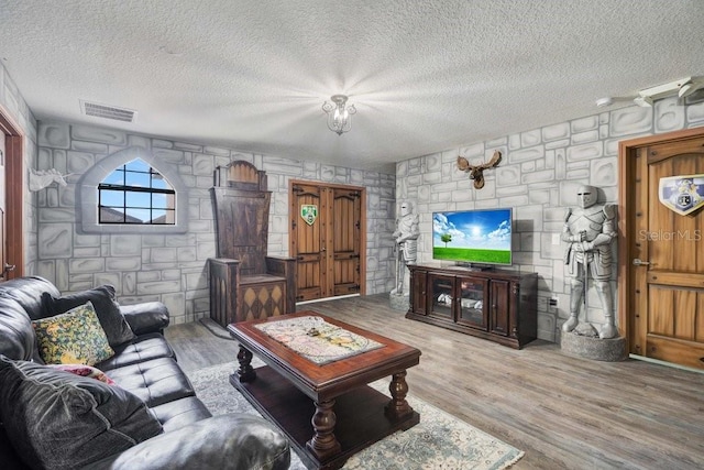 living room featuring light hardwood / wood-style flooring and a textured ceiling