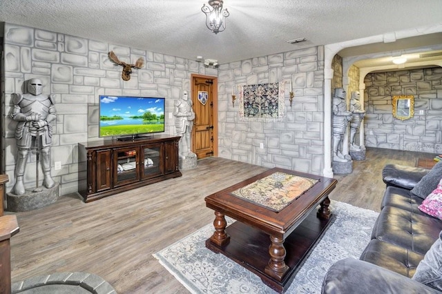 living room with light wood-type flooring and a textured ceiling