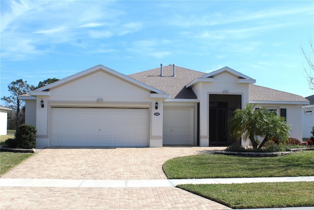 single story home with a garage and a front lawn