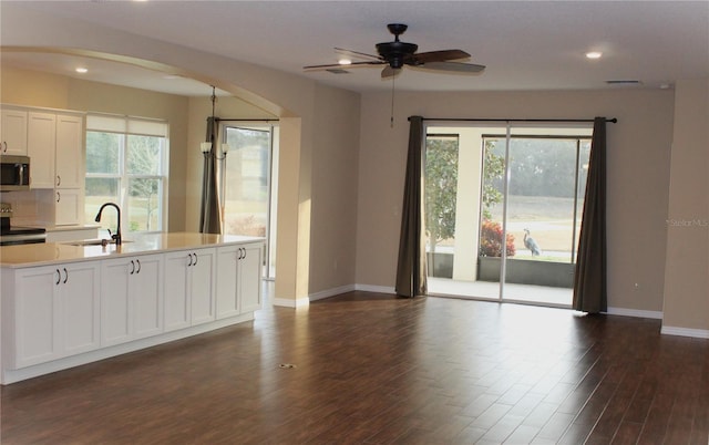 kitchen featuring range with electric stovetop, dark hardwood / wood-style floors, tasteful backsplash, sink, and white cabinets