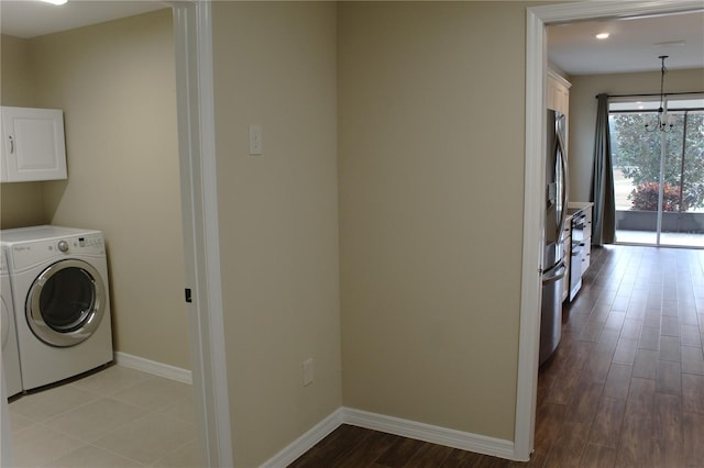 laundry room featuring cabinets, washer and dryer, and light wood-type flooring