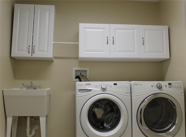 laundry area with cabinets, washer and clothes dryer, and sink