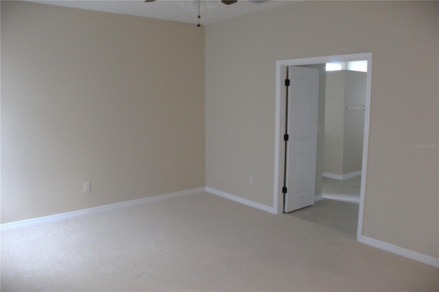 unfurnished room with light colored carpet and ceiling fan