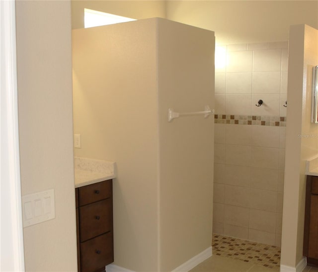 bathroom with vanity and tiled shower