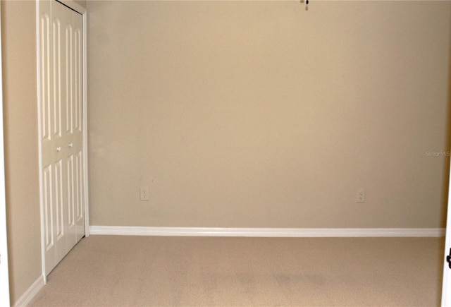 unfurnished room featuring light carpet