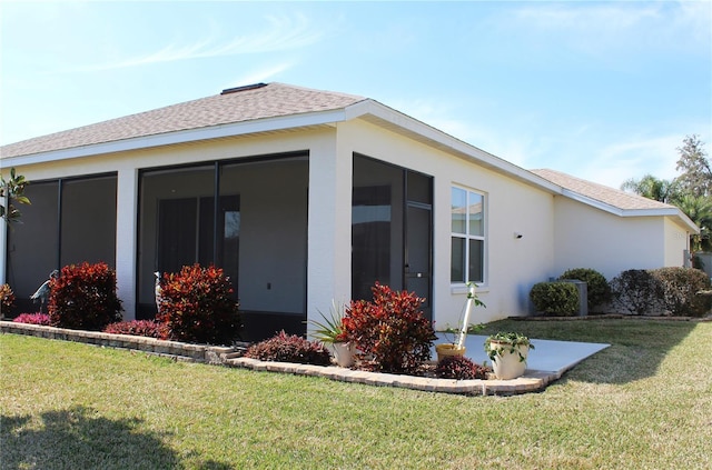 view of home's exterior featuring a yard and a sunroom