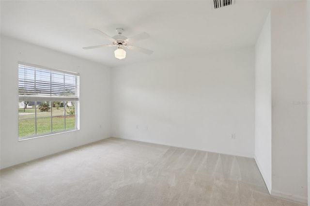 spare room with ceiling fan and light carpet