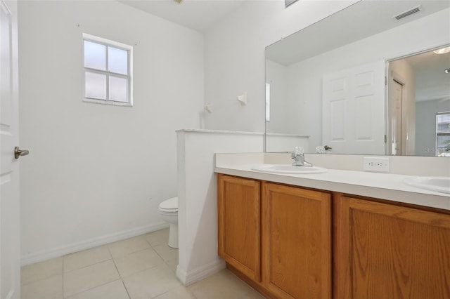 bathroom with toilet, vanity, and tile patterned floors