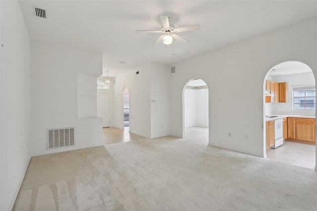 unfurnished living room with ceiling fan and light carpet