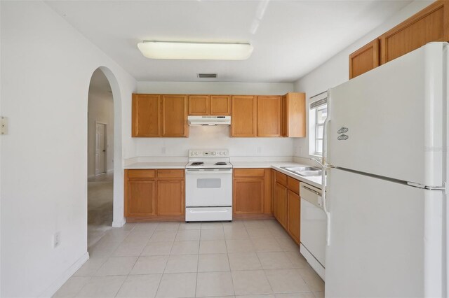 kitchen featuring white appliances, sink, and light tile patterned flooring