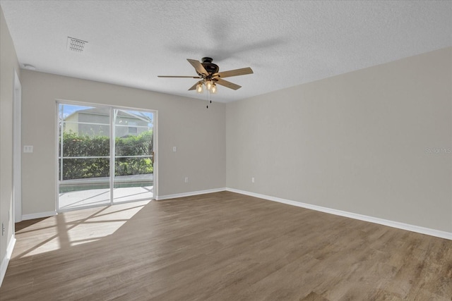 empty room with ceiling fan, hardwood / wood-style floors, and a textured ceiling