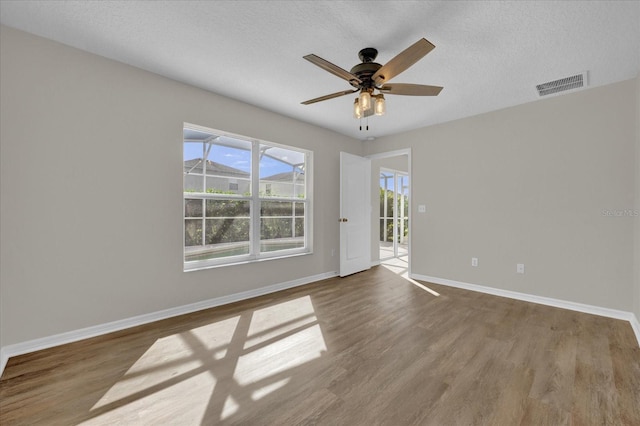 empty room featuring ceiling fan, hardwood / wood-style floors, and a textured ceiling