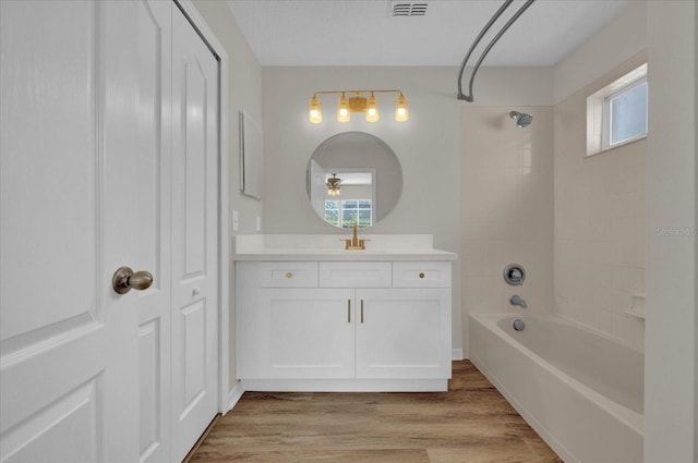 bathroom featuring vanity, hardwood / wood-style flooring, and  shower combination