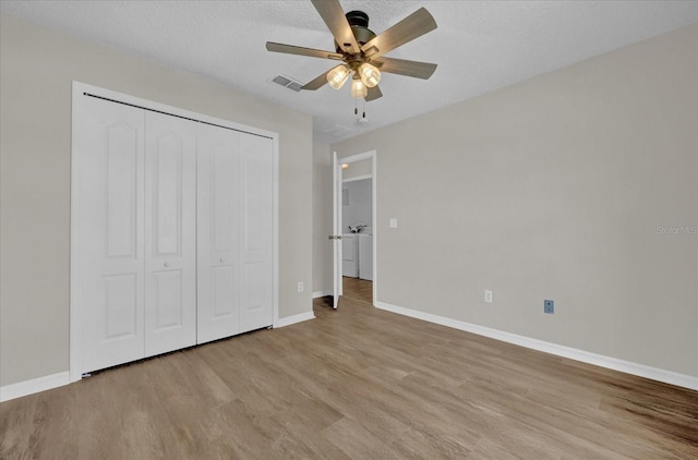 unfurnished bedroom featuring light hardwood / wood-style flooring, a textured ceiling, ceiling fan, and a closet