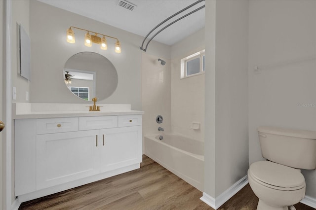 full bathroom with vanity, hardwood / wood-style floors, tiled shower / bath combo, and toilet