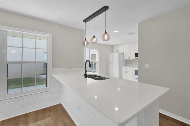 kitchen with sink, white cabinetry, dark hardwood / wood-style floors, pendant lighting, and white appliances