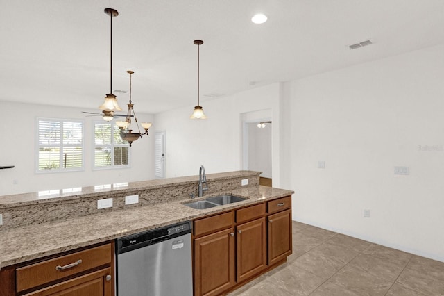 kitchen featuring dishwasher, sink, light stone countertops, light tile patterned flooring, and decorative light fixtures