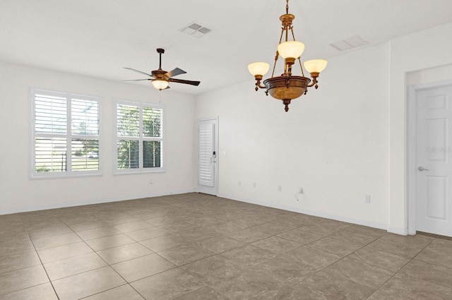 tiled empty room featuring ceiling fan with notable chandelier