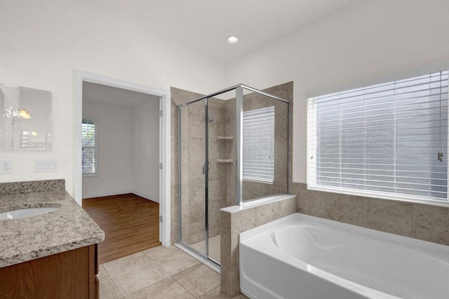 bathroom featuring vanity, plus walk in shower, and wood-type flooring