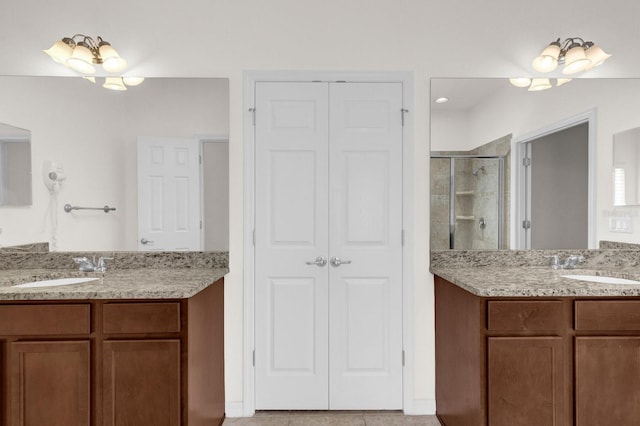 bathroom featuring a shower with door, tile patterned floors, and vanity