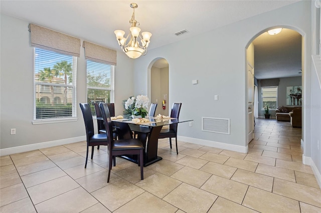 tiled dining space featuring an inviting chandelier