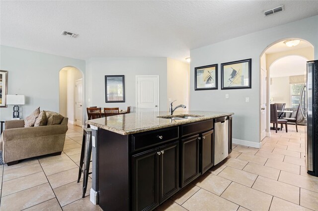 4204 Oakview Dr, Davenport, FL 33837 - kitchen with arched walkways, a sink, stainless steel appliances, light tile patterned floors, and open floor plan