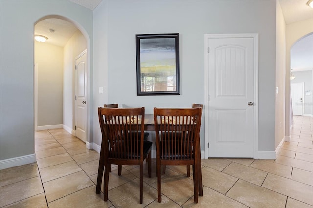 dining space featuring a textured ceiling and light tile patterned floors