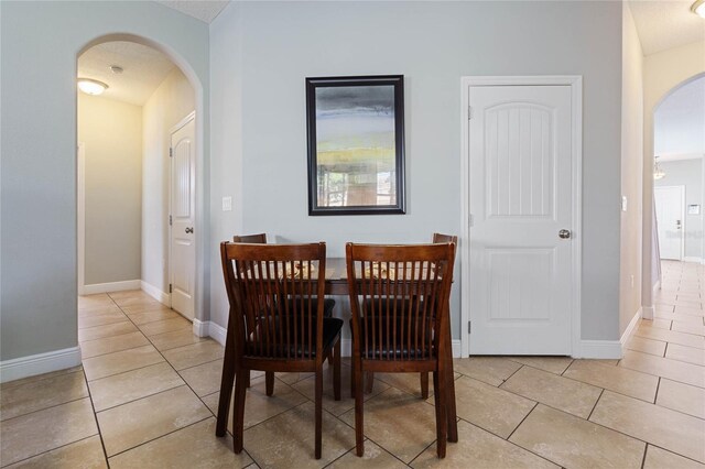 4204 Oakview Dr, Davenport, FL 33837 - dining space with arched walkways, light tile patterned floors, and baseboards