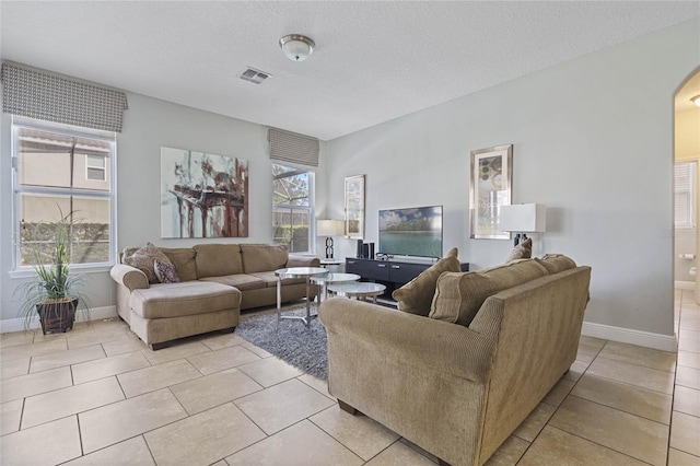 tiled living room featuring a textured ceiling