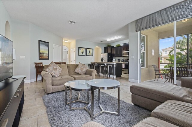 4204 Oakview Dr, Davenport, FL 33837 - living room with light tile patterned flooring, arched walkways, and baseboards