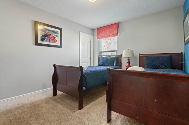 bedroom with light colored carpet and a textured ceiling