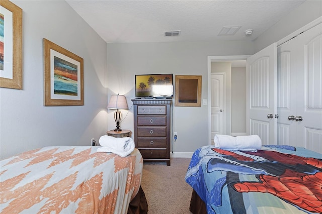 bedroom with a closet, carpet, and a textured ceiling