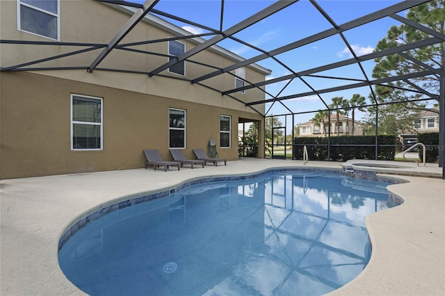 view of pool featuring glass enclosure, a patio area, and an in ground hot tub