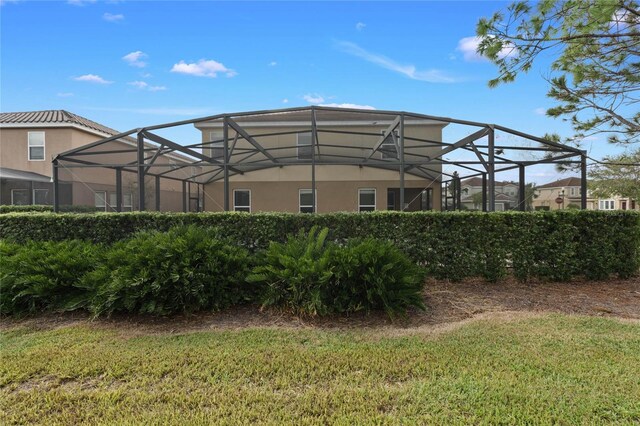 4204 Oakview Dr, Davenport, FL 33837 - rear view of house featuring a lanai, stucco siding, and a yard