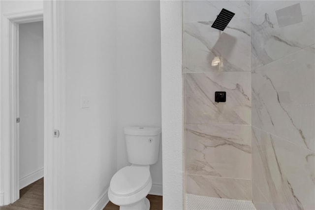 bathroom featuring tiled shower, hardwood / wood-style flooring, and toilet