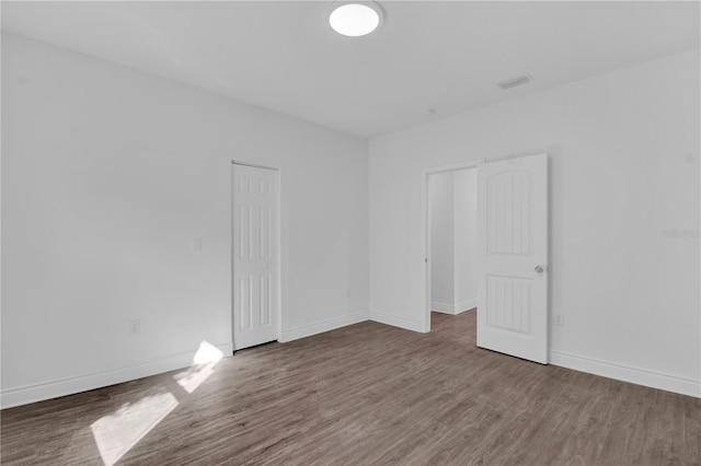 unfurnished room with dark wood-type flooring